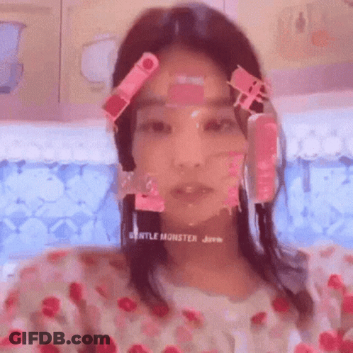 A Woman With Pink Stickers On Her Face Is Taking A Selfie In A Bathtub . GIF