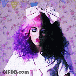 A Woman With Purple And Black Hair Has A Pink Bow On Her Head GIF