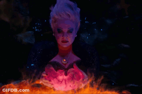 A Woman With Purple Hair And A Necklace With A Red Stone GIF