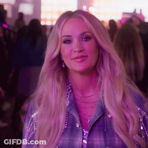A Woman With Purple Hair And A Plaid Shirt Smiles For The Camera GIF