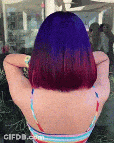 A Woman With Purple Hair And A Rainbow Tank Top GIF