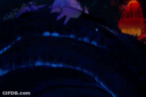 A Woman With Purple Hair And Black Nails Is Wearing A Ring On Her Finger GIF
