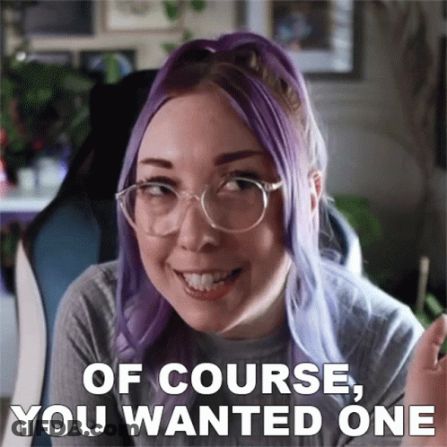 A Woman With Purple Hair And Glasses Is Smiling With The Words Of Course You Wanted One Below Her GIF