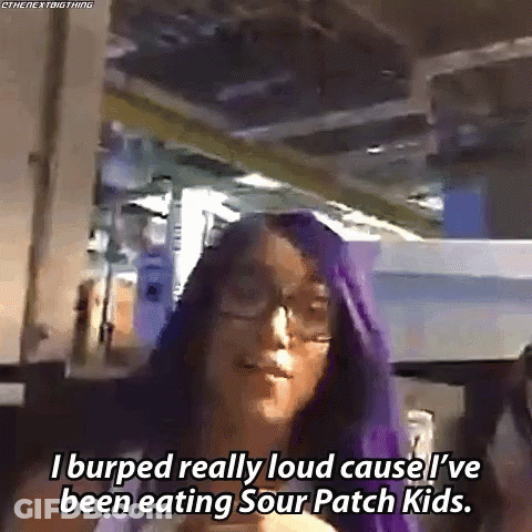 A Woman With Purple Hair And Glasses Is Talking About Sour Patch Kids GIF