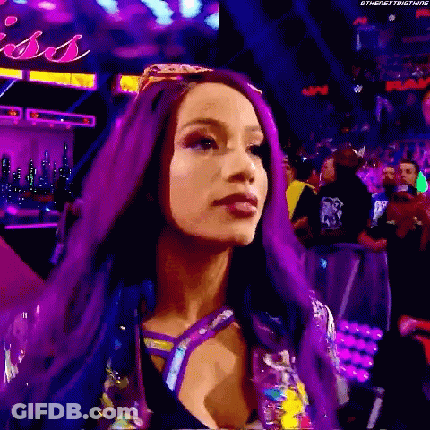 A Woman With Purple Hair Is Standing In Front Of A Crowd In A Stadium . GIF