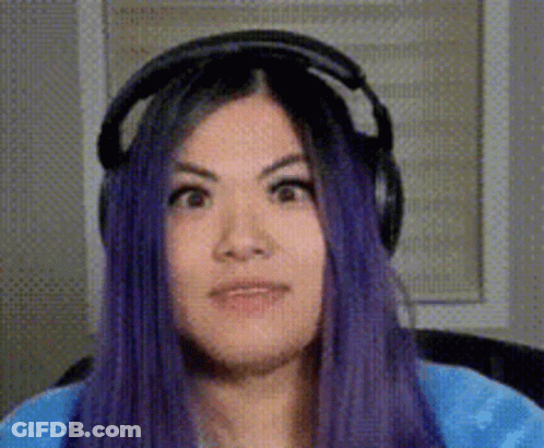 A Woman With Purple Hair Is Wearing Headphones And Making A Face . GIF