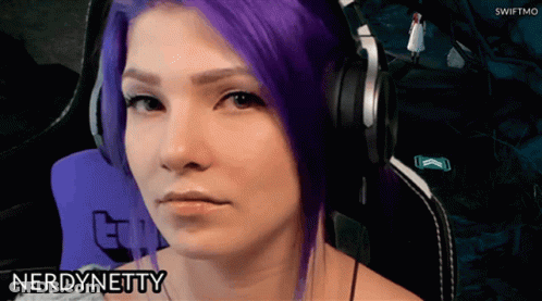 A Woman With Purple Hair Is Wearing Headphones And The Name Nerd Netty Is On The Bottom Right GIF