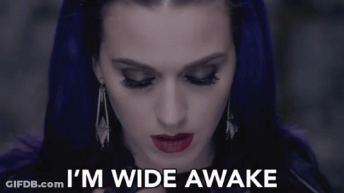 A Woman With Purple Hair Says " I 'M Wide Awake " In White Letters GIF
