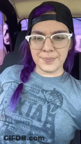 A Woman With Purple Hair Wearing Glasses And A T-Shirt That Says ' I Love Kansas ' On It GIF