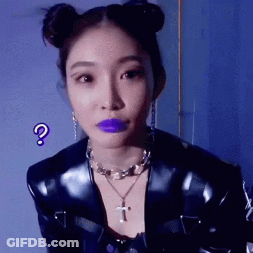 A Woman With Purple Lipstick And Buns On Her Hair Is Wearing A Black Jacket And A Necklace . GIF