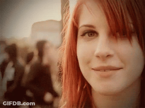 A Woman With Red Hair And A Piercing In Her Lip Smiles GIF