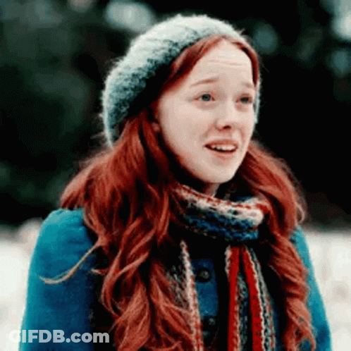 A Woman With Red Hair And A Scarf Is Wearing A Hat And Scarf . GIF