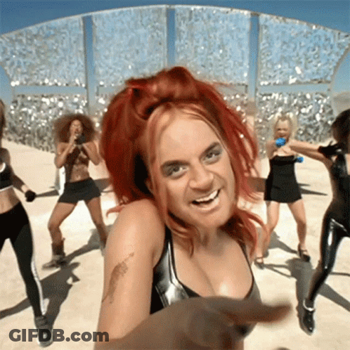 A Woman With Red Hair And A Tattoo On Her Arm Is Dancing With A Group Of Women GIF