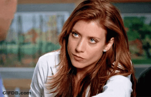 A Woman With Red Hair And Blue Eyes Is Looking At The Camera GIF
