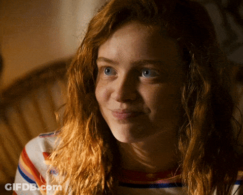 A Woman With Red Hair And Blue Eyes Is Smiling For The Camera GIF