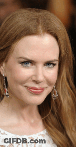 A Woman With Red Hair And Blue Eyes Is Smiling GIF