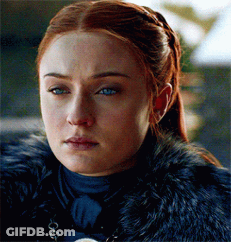 A Woman With Red Hair And Blue Eyes Is Wearing A Black Fur Coat GIF