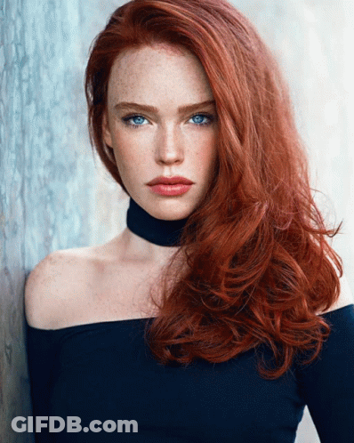 A Woman With Red Hair And Blue Eyes Is Wearing A Choker Around Her Neck GIF