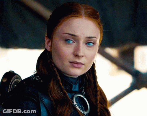 A Woman With Red Hair And Blue Eyes Is Wearing A Necklace GIF