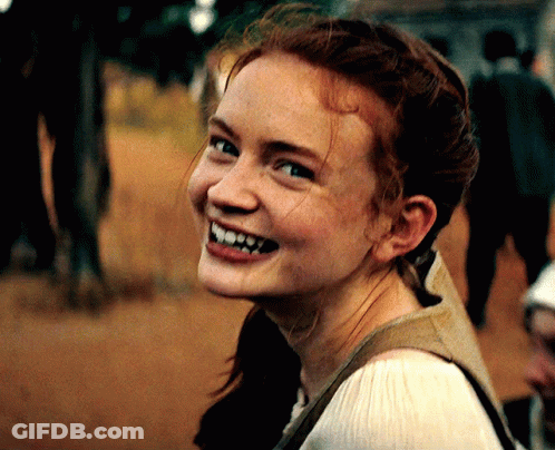 A Woman With Red Hair And Freckles Is Smiling GIF