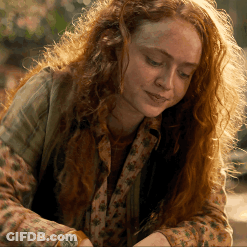 A Woman With Red Hair And Freckles Is Wearing A Watch GIF