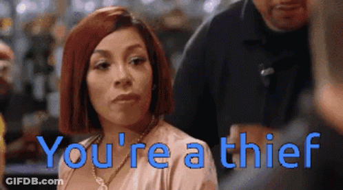 A Woman With Red Hair And The Words You 'Re A Thief Behind Her GIF