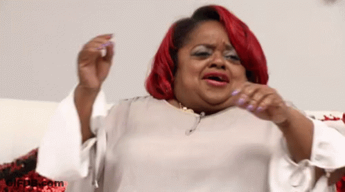 A Woman With Red Hair And White Nails Is Making A Face GIF