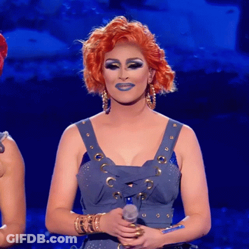 A Woman With Red Hair Holds A Microphone In Her Hand GIF