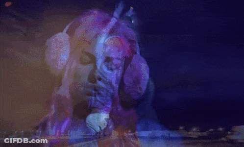A Woman With Red Hair Is Dancing In A Dark Room GIF