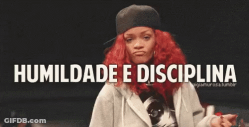 A Woman With Red Hair Is Dancing In Front Of A Sign That Says Humildade E Disciplina . GIF