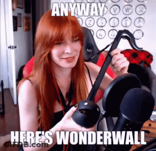 A Woman With Red Hair Is Holding A Virtual Reality Headset In Front Of A Microphone . GIF