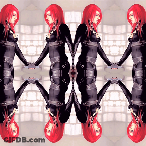 A Woman With Red Hair Is Holding Hands With Her Reflection In A Mirror GIF