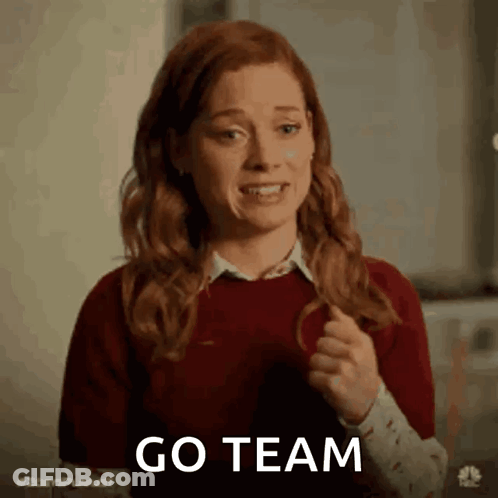 A Woman With Red Hair Is Holding Her Hair In A Ponytail And Saying Go Team . GIF
