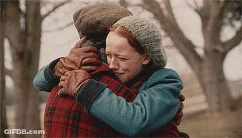 A Woman With Red Hair Is Hugging A Man In A Plaid Jacket GIF