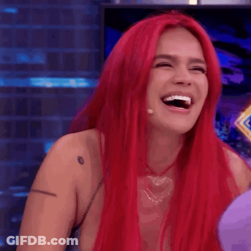 A Woman With Red Hair Is Laughing With Her Mouth Wide Open GIF