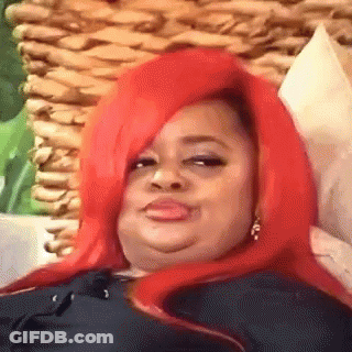 A Woman With Red Hair Is Laying On A Couch And Making A Face . GIF