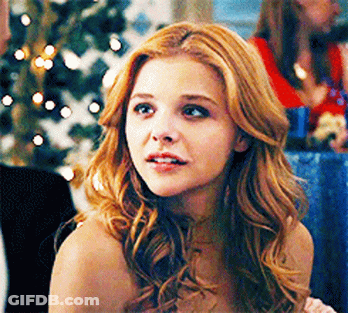 A Woman With Red Hair Is Looking At The Camera GIF