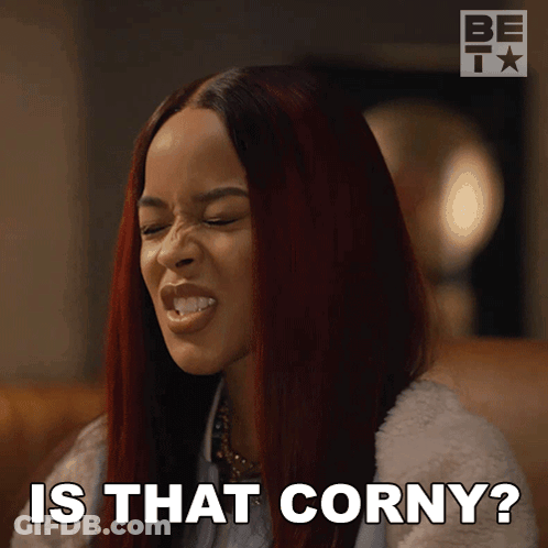 A Woman With Red Hair Is Making A Funny Face And Says " Is That Corny " GIF