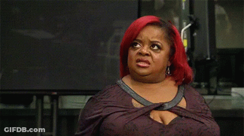 A Woman With Red Hair Is Making A Funny Face In Front Of A Television . GIF