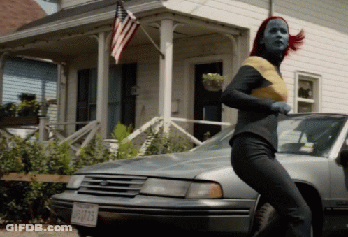 A Woman With Red Hair Is Running In Front Of A Car With A License Plate That Says Jfu725 GIF