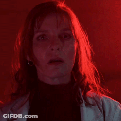 A Woman With Red Hair Is Saying " You 'Ve Been A " In A Dark Room GIF