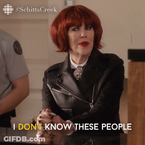 A Woman With Red Hair Is Sitting At A Table And Says " I Dont Know These People " GIF