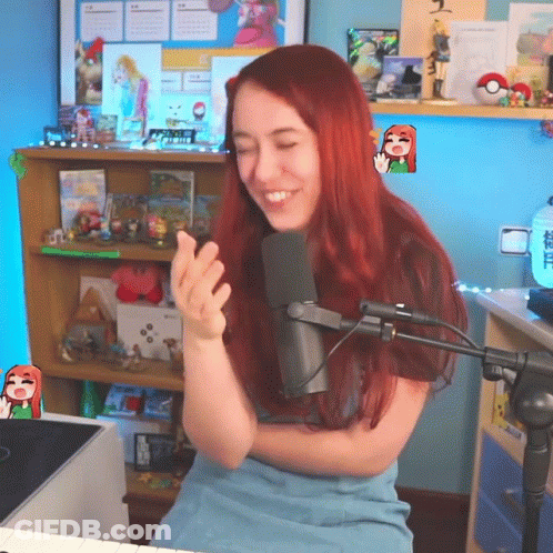 A Woman With Red Hair Is Sitting In Front Of A Microphone And Smiling GIF