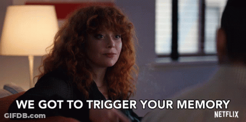 A Woman With Red Hair Is Sitting Next To A Man And Says We Got To Trigger Your Memory GIF