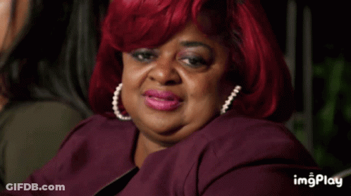 A Woman With Red Hair Is Sitting Next To Another Woman In A Dark Room With The Words Imgplay Below Her GIF