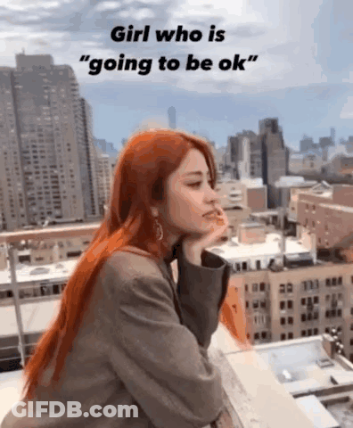 A Woman With Red Hair Is Sitting On A Balcony Overlooking A City With A City Skyline In The Background . GIF