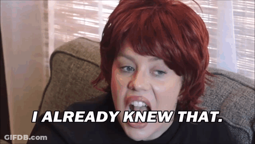 A Woman With Red Hair Is Sitting On A Couch And Says " I Already Knew That " GIF