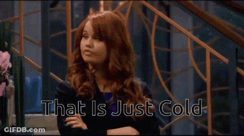 A Woman With Red Hair Is Sitting With Her Arms Crossed And The Words That Is Just Cold Behind Her GIF