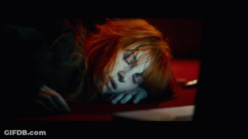 A Woman With Red Hair Is Sleeping On A Red Couch GIF
