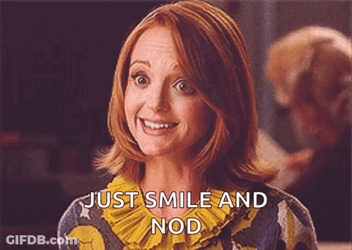 A Woman With Red Hair Is Smiling And Says Just Smile And Nod GIF